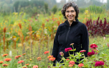 An image of Claire Kremen in a field of flowers. Photo by Richard Amies.