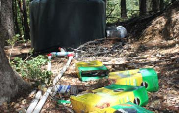 Discarded fertilizer boxes with water tank in the background