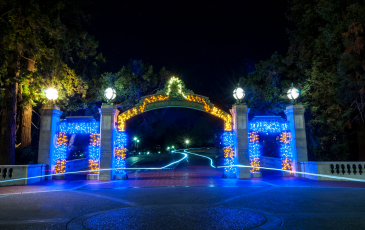 Sather gate lit up in blue and gold