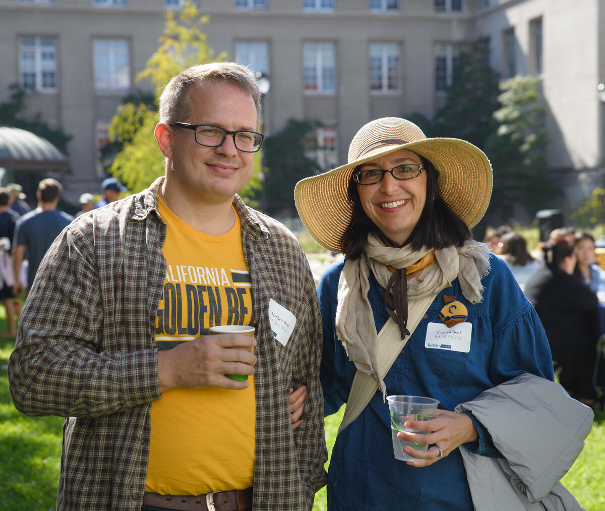 Two smiling people dressed in gold and blue
