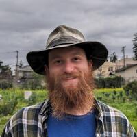 Headshot of Bradlee Mcanally with a farm in the background