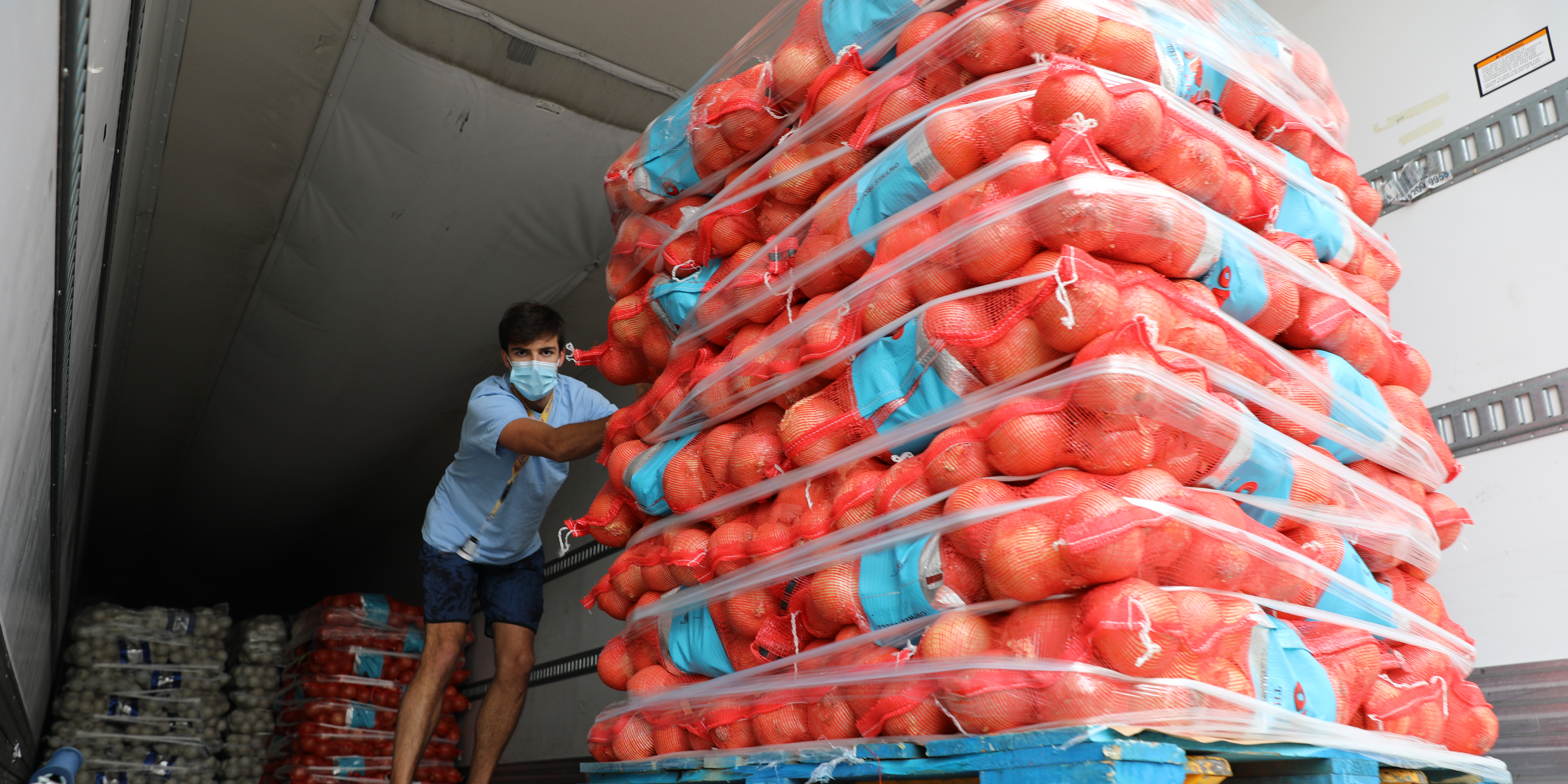 Person pushing tomatoes on cart